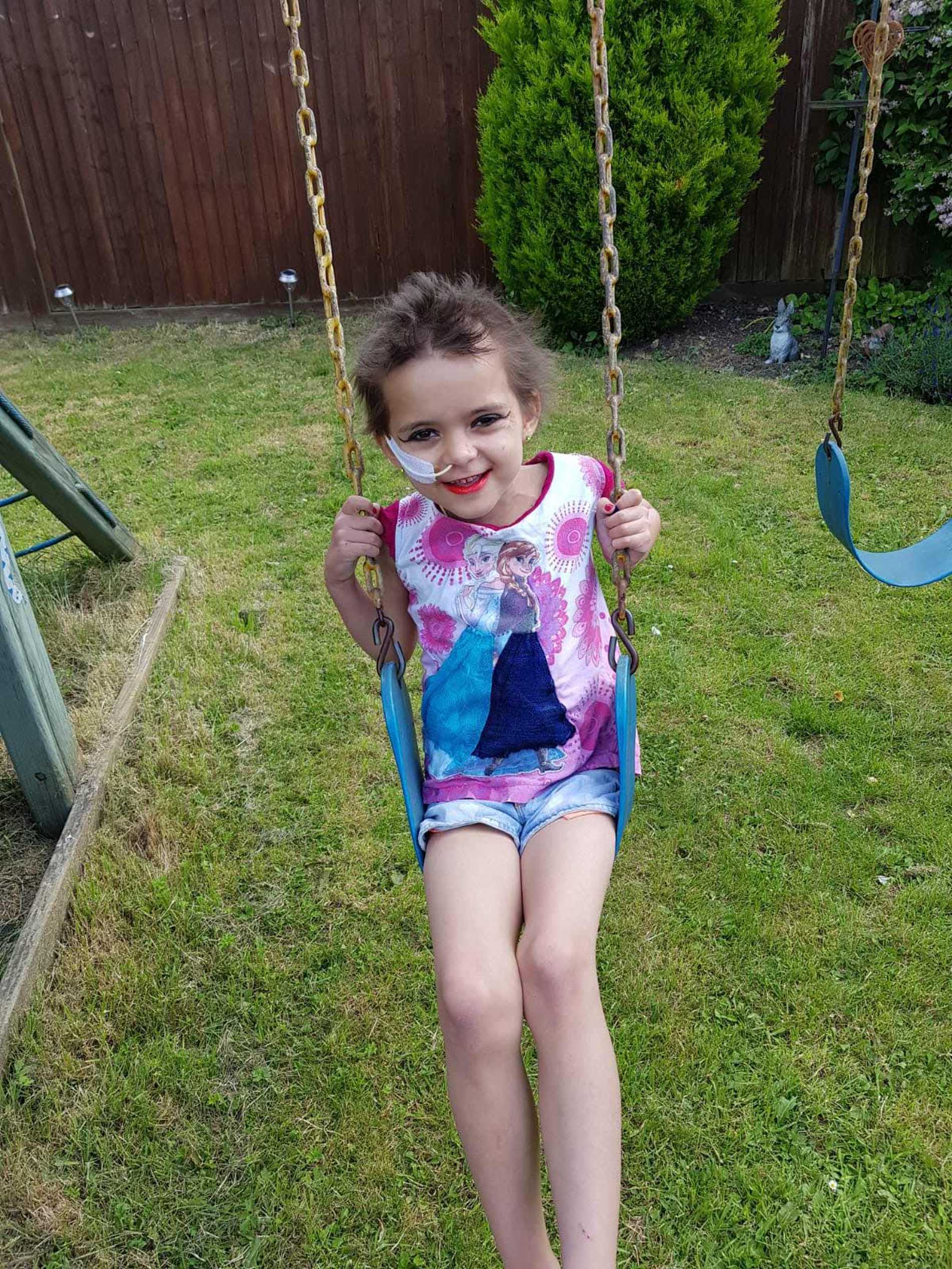 Kelsey playing on a swing