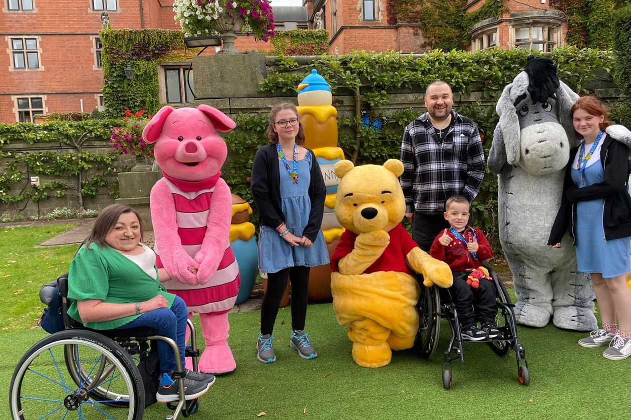 Lincoln posing in the gardens of the hotel with Winnie the Pooh and other Disney characters.