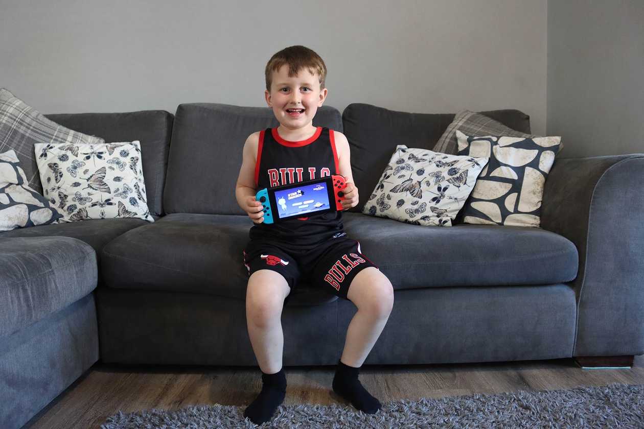 Oliver, proudly holding up his new Nintendo Switch.