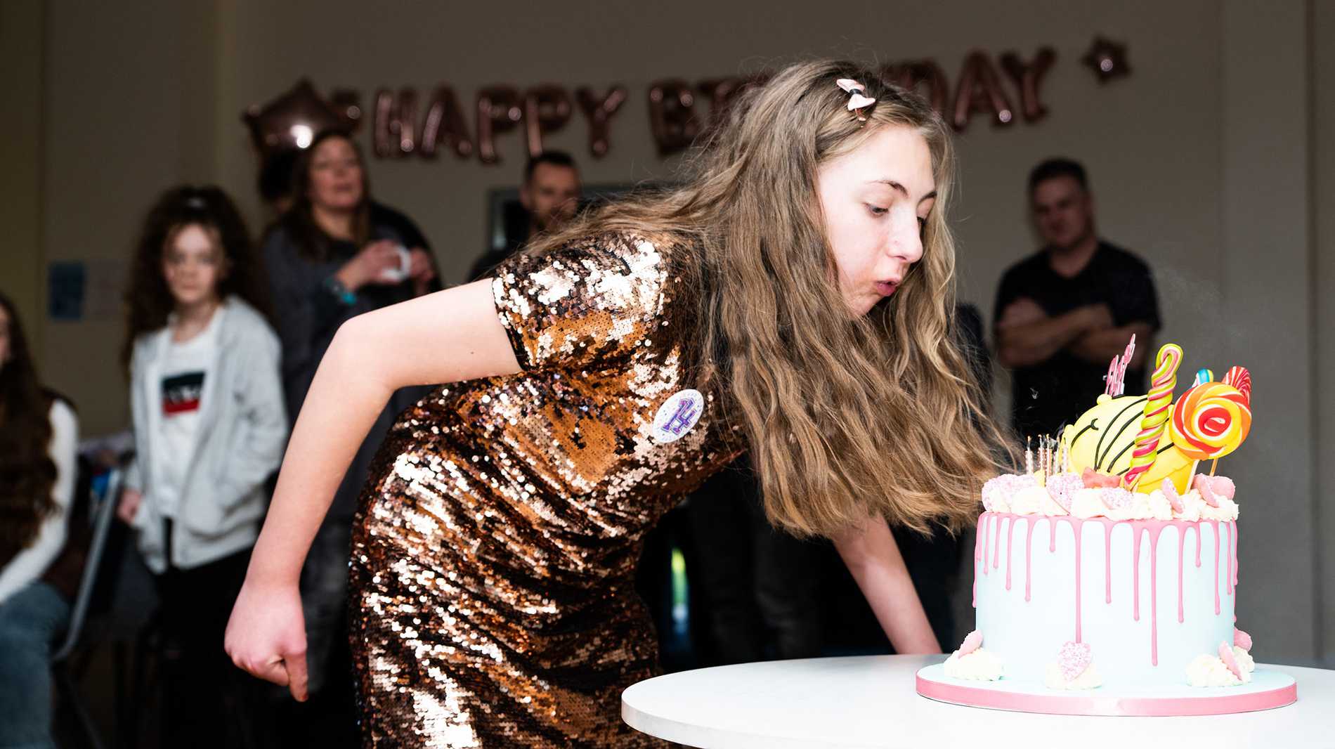 Eloise blowing out the candles on her birthday cake.